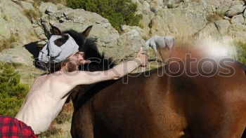 Similar – Image, Stock Photo Portrait of a young male adjusting the saddle on his horse