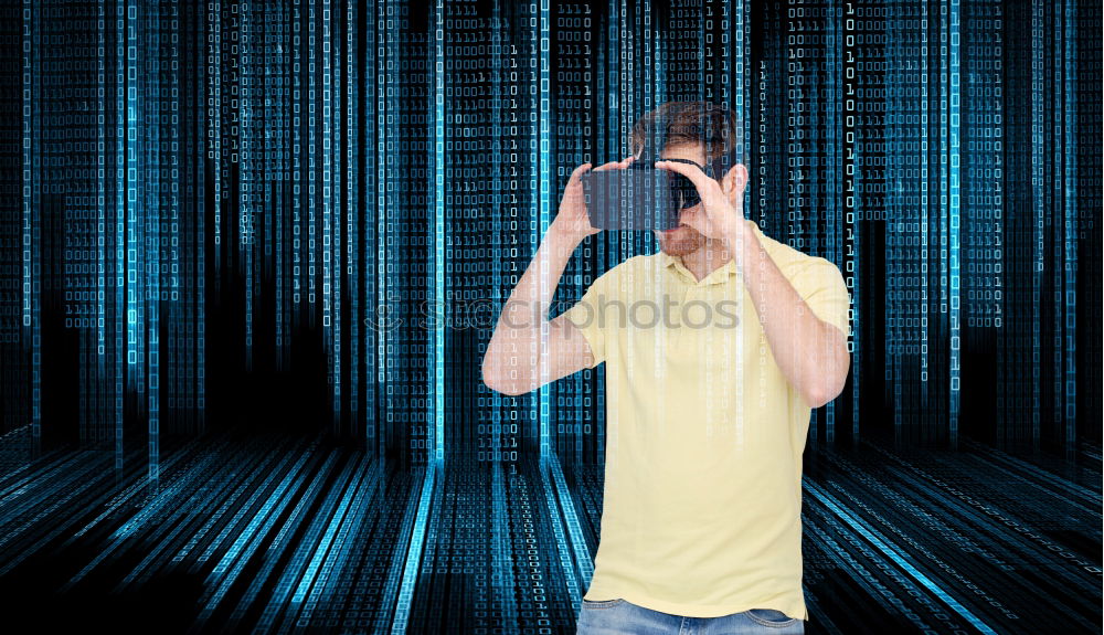 Bearded man dressed in blue t-shirt with binoculars posing against black background