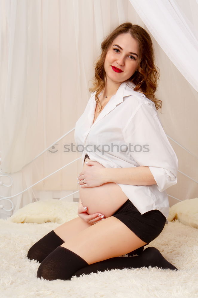 Young woman in undershirt sitting on a flowered couch and looking sideways into the camera