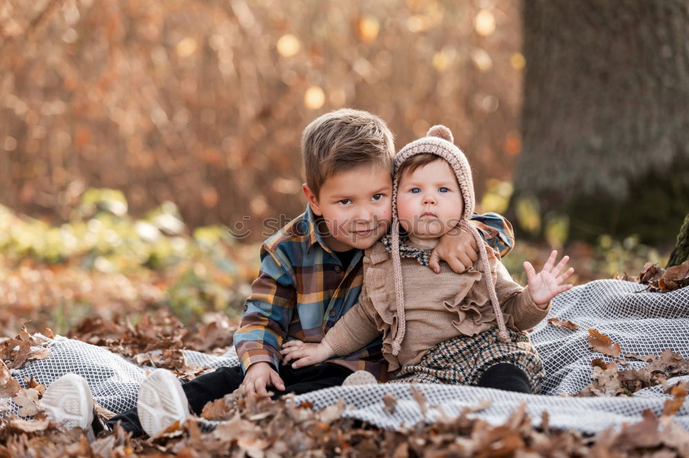 Similar – Two adorable young brothers outdoors in winter wrapped up warmly against the chill weather with the older boy cuddling his toddler sibling on his lap