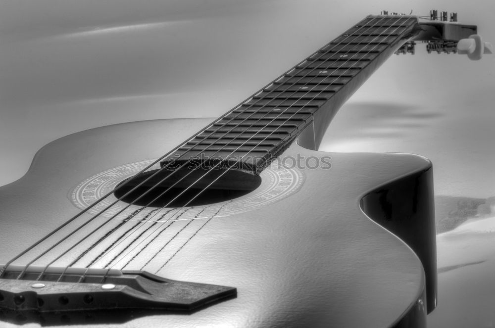 Similar – Image, Stock Photo A black electric guitar on a wooden board table photographed from the guitar head perspective. The focus is on the side holder and knob.