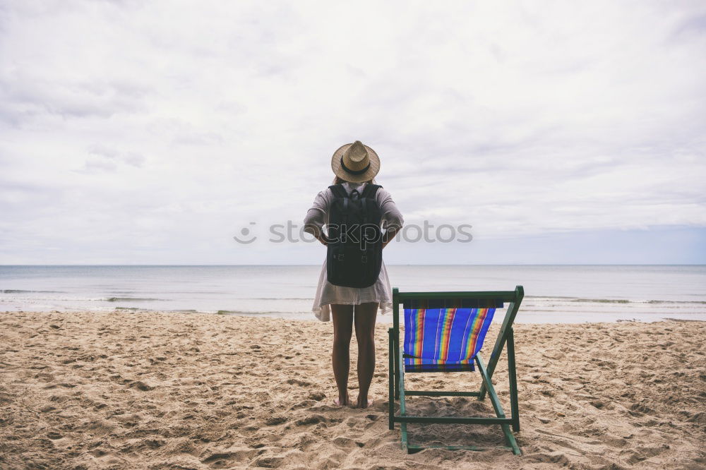 Similar – Rear view of a woman sitting on a wooden bench and looking at a lake