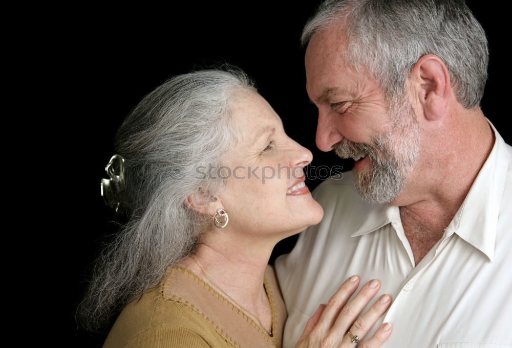 Smiling senior couple looks lovingly into each other’s eyes