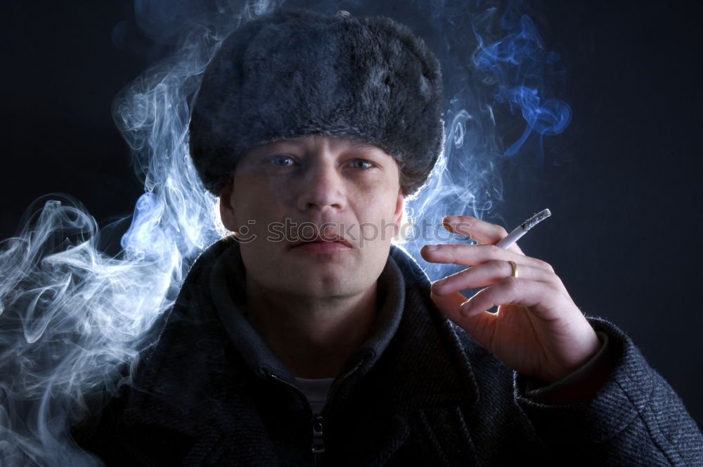 Similar – Young man vaping, studio shot. Bearded guy with sunglasses blowing a cloud of smoke on black background. Concept of smoking and steam without nicotine.