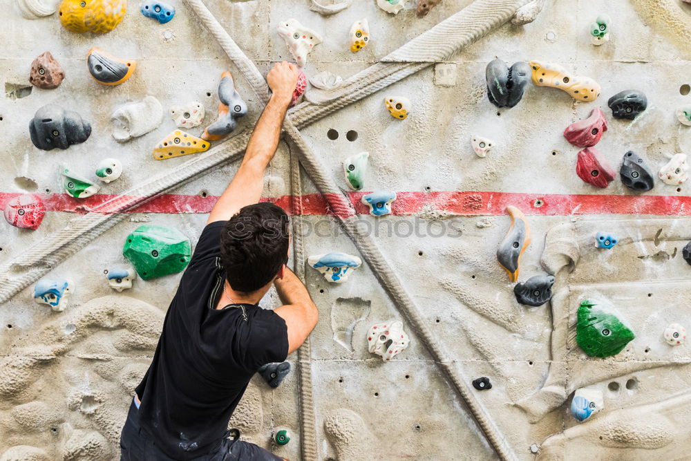 Similar – A Man practicing rock climbing on artificial wall indoors