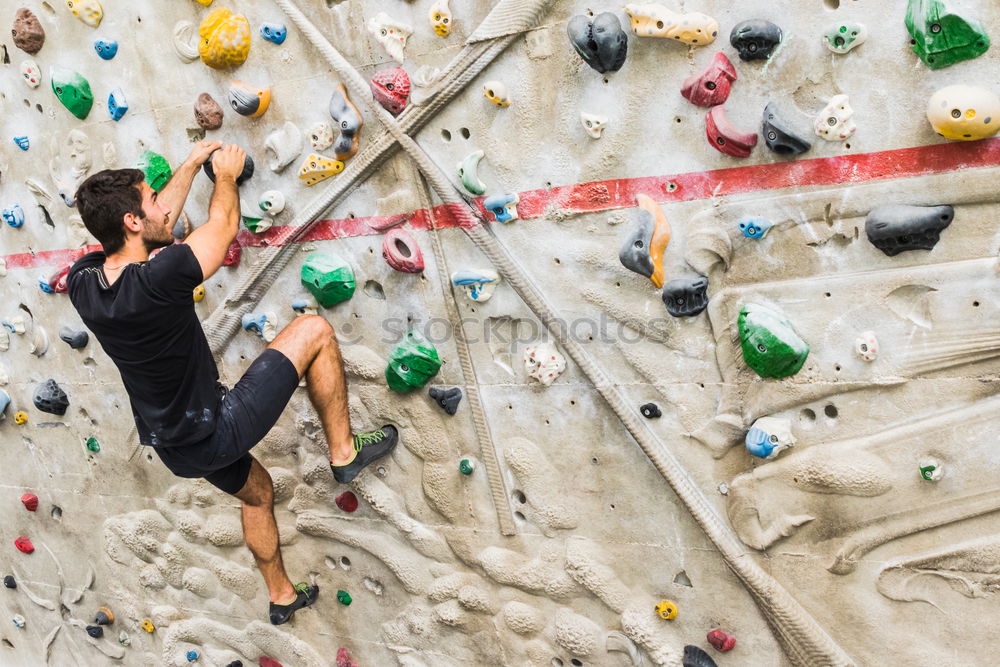 Similar – A Man practicing rock climbing on artificial wall indoors