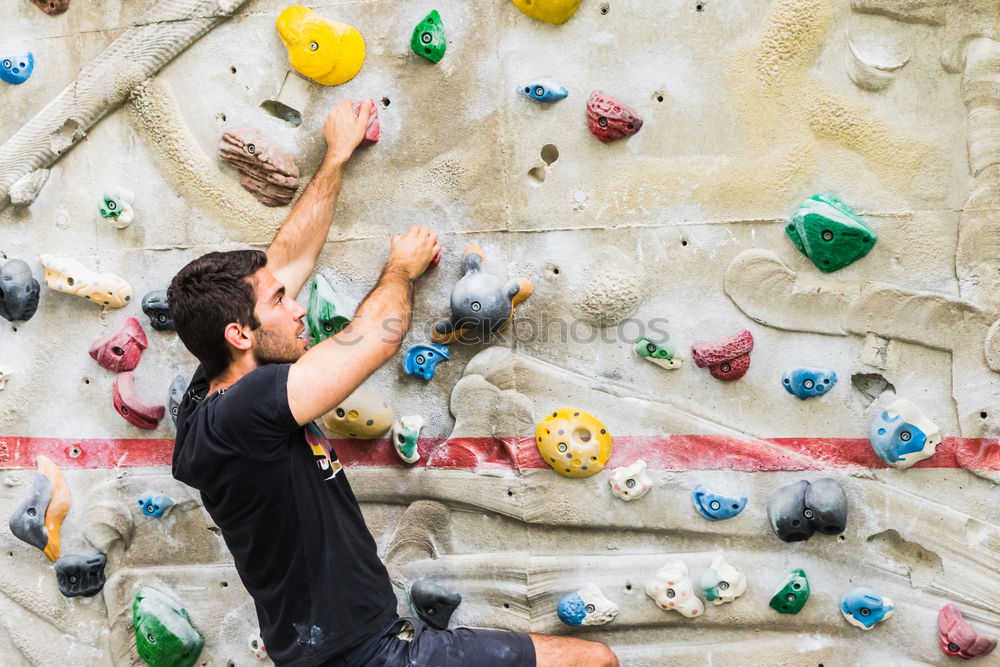 Similar – A Man practicing rock climbing on artificial wall indoors