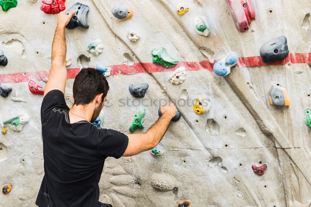 Similar – A Man practicing rock climbing on artificial wall indoors