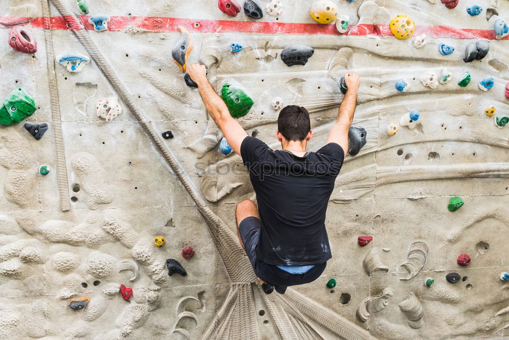 Similar – A Man practicing rock climbing on artificial wall indoors