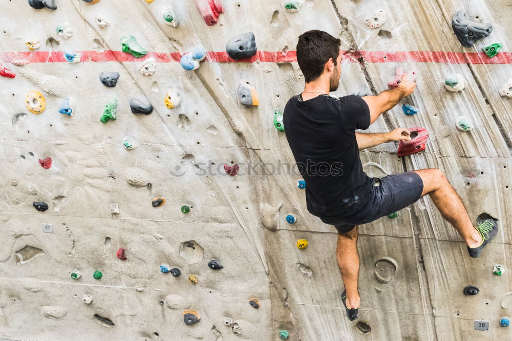 Similar – A Man practicing rock climbing on artificial wall indoors