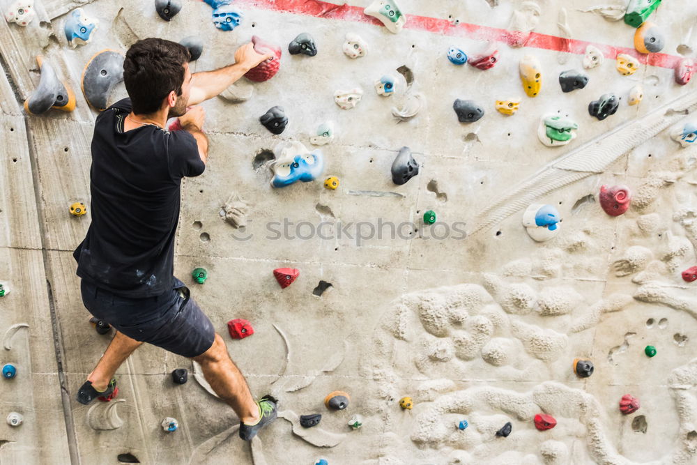 Similar – A Man practicing rock climbing on artificial wall indoors