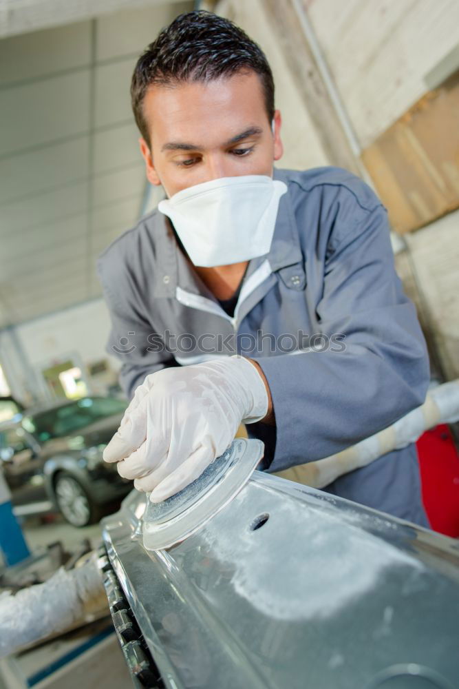 Similar – Man with a dust mask and goggles working on a circular saw