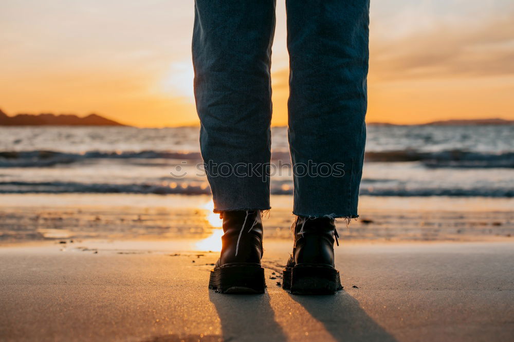 Close-up of man standing on longboard on promenade