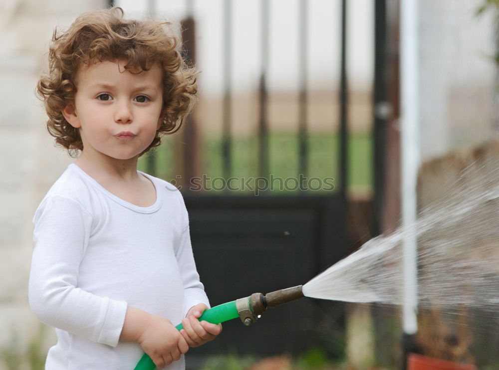 adorable boy watering the plants