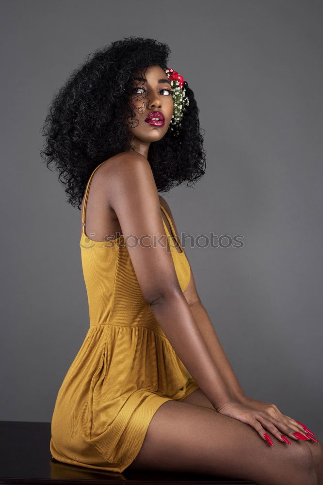 Stylish black woman in trendy outfit in studio