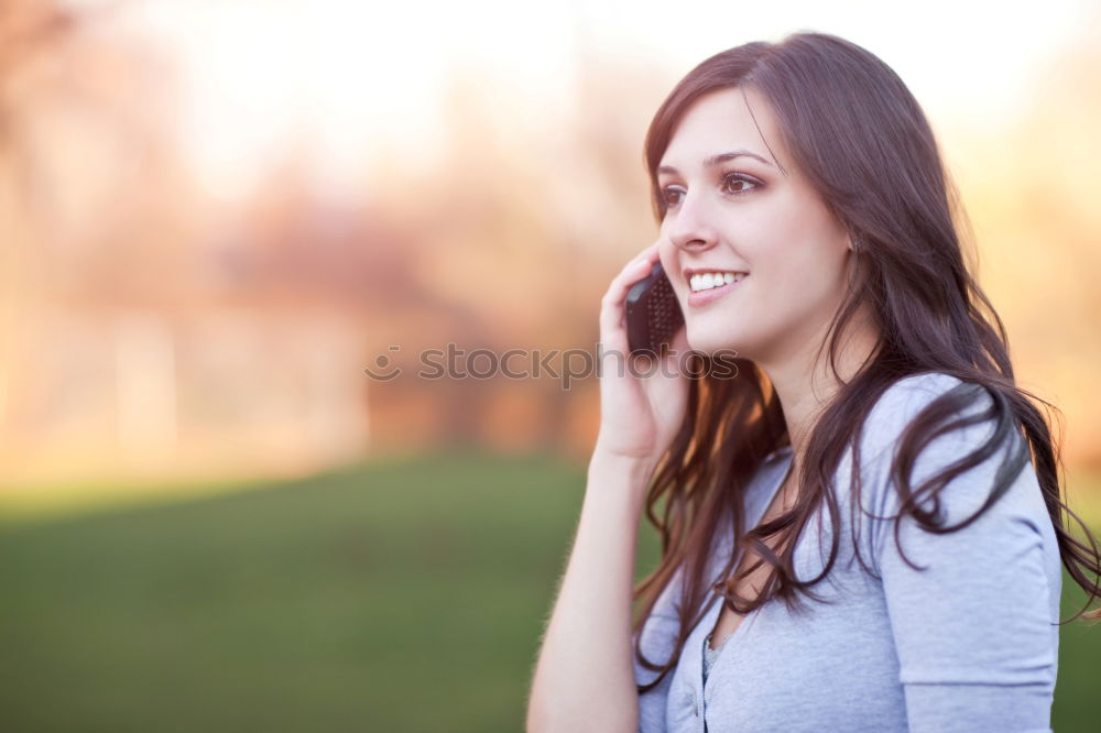 Similar – Image, Stock Photo Smiling young woman chatting on a mobile in autumn