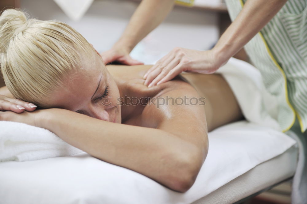 Similar – Woman at beauty spa getting a procedure with hot stones while massage therapist doing arm massage