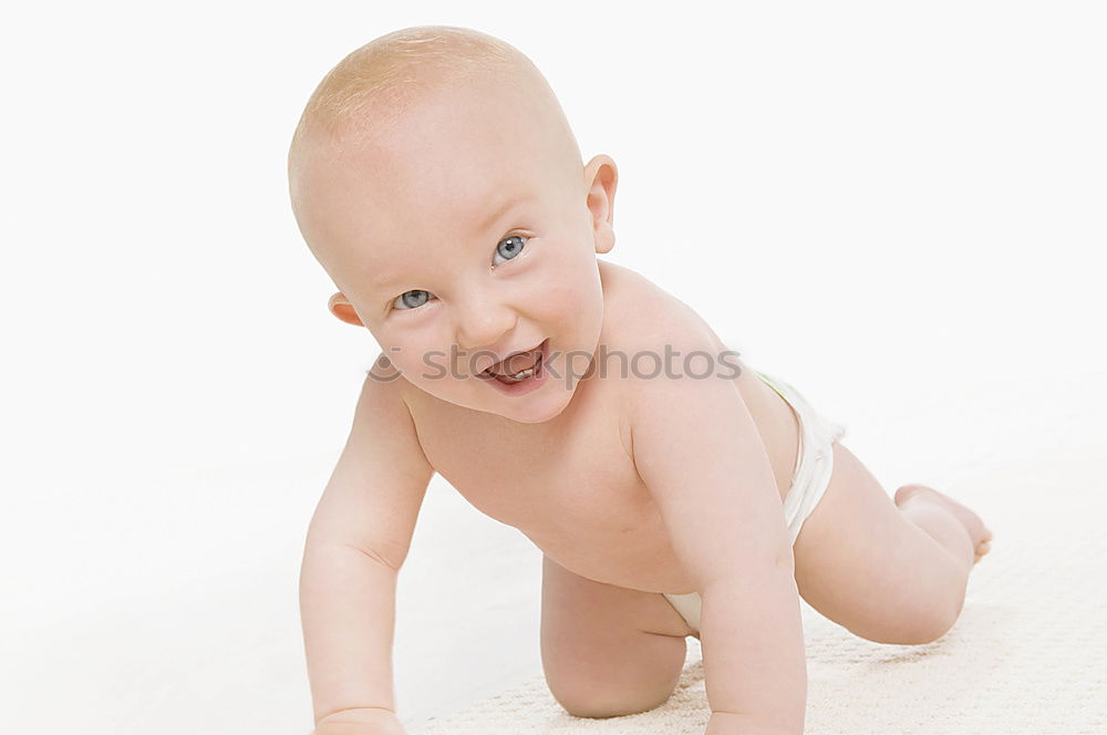 Happy baby girl, four months old, on the bed with pacifier.