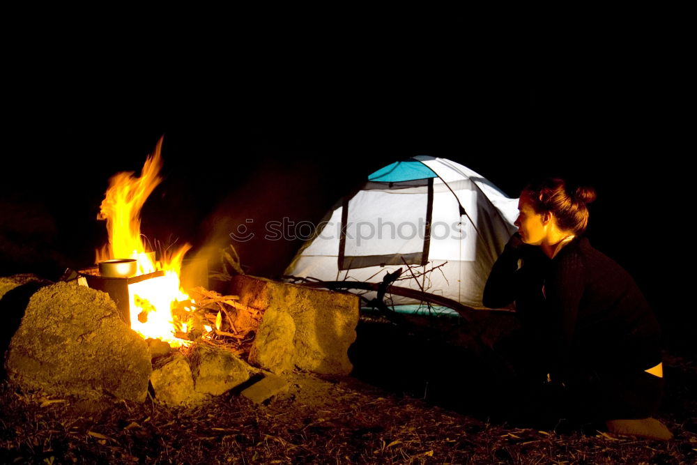 Similar – Man lights a fire in the fireplace in nature at night