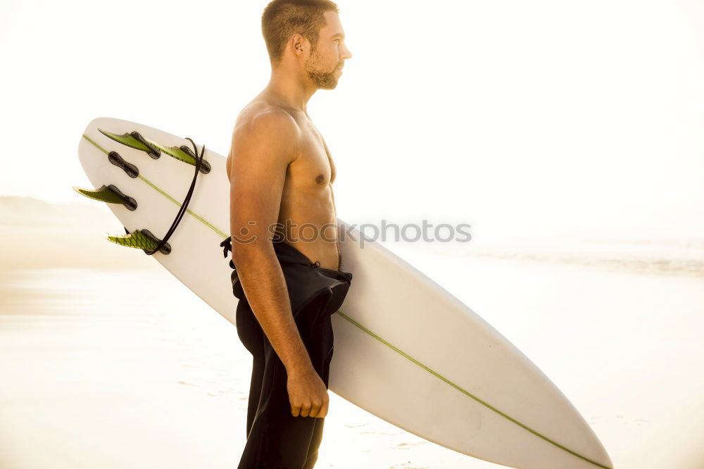 Similar – Man with tattoos holding skateboard at shore. Back view.