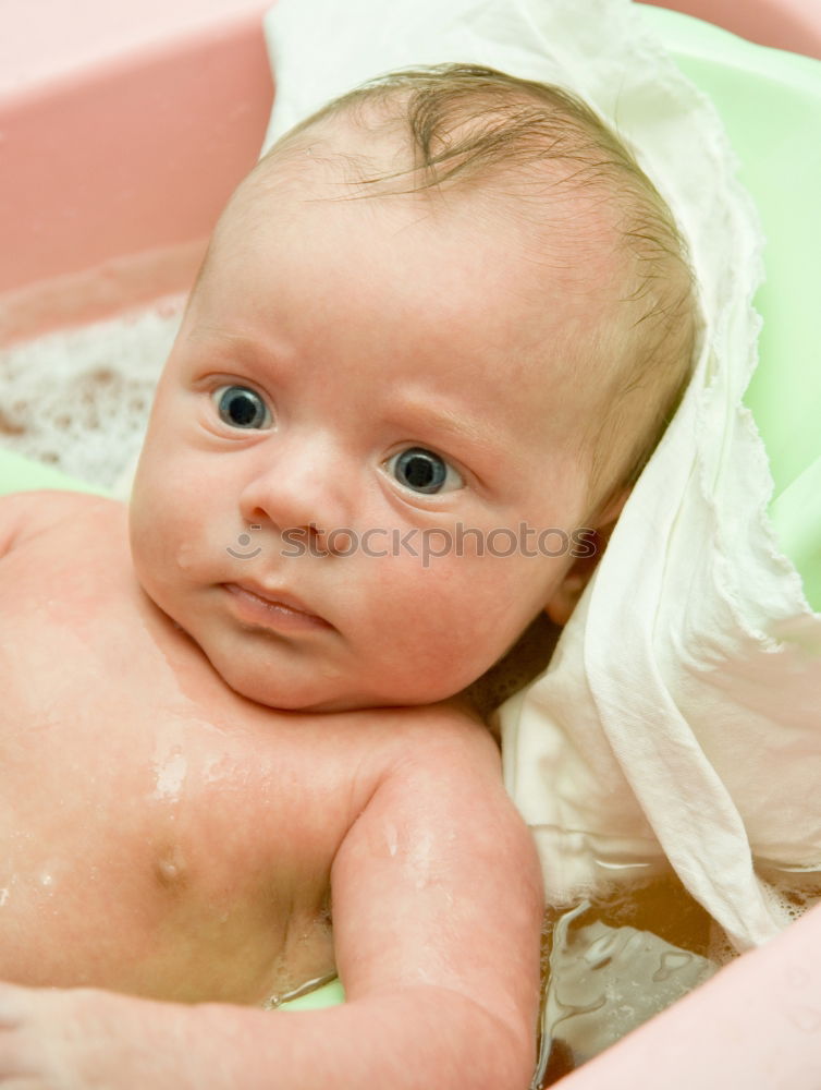 Bathing newborn baby girl.