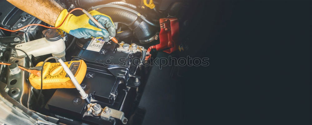 Mechanic man welding metal material in garage.