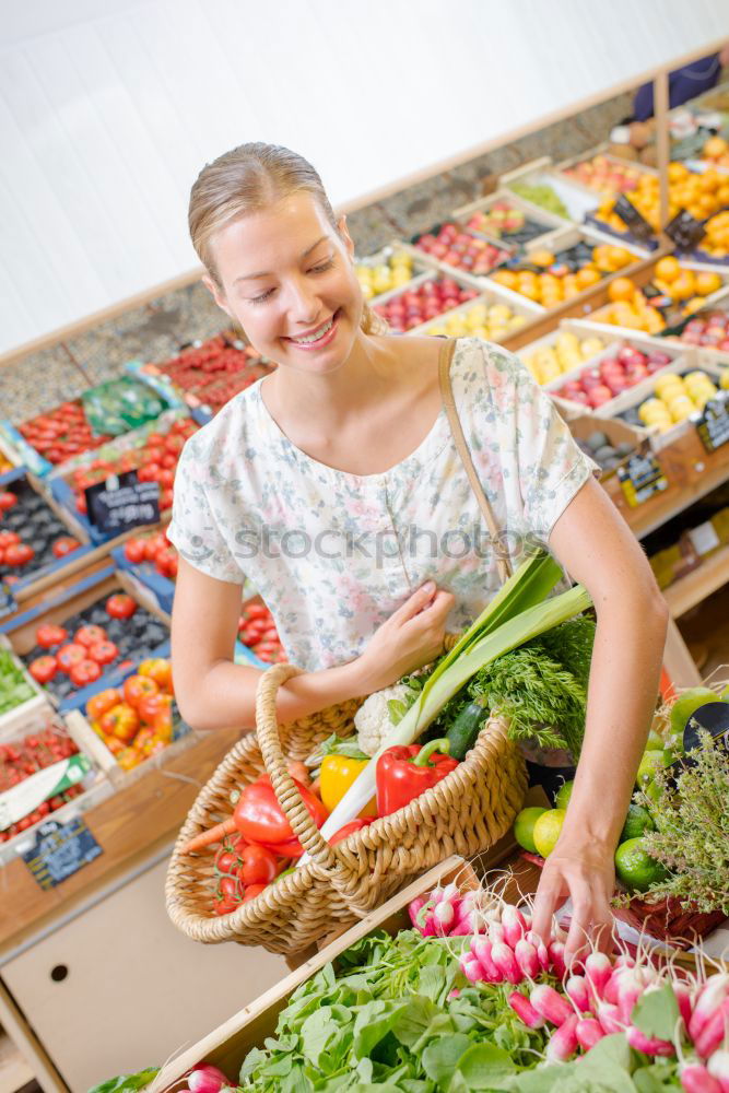 Similar – Image, Stock Photo Young woman shopping for fresh tomatoes at an open-air stall choosing items from a row of wooden boxes