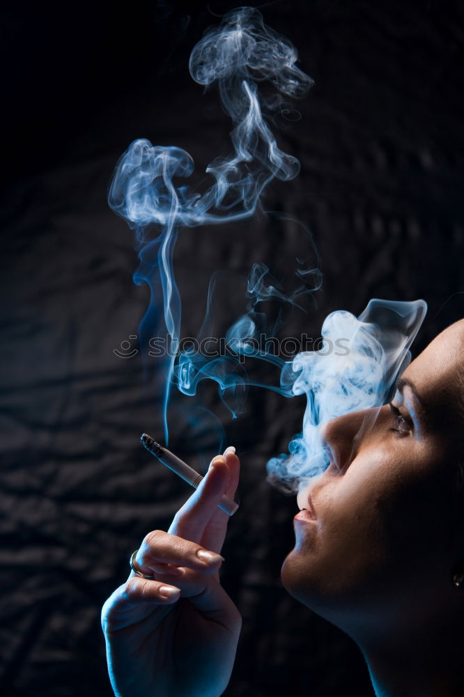 Young woman smoking near window