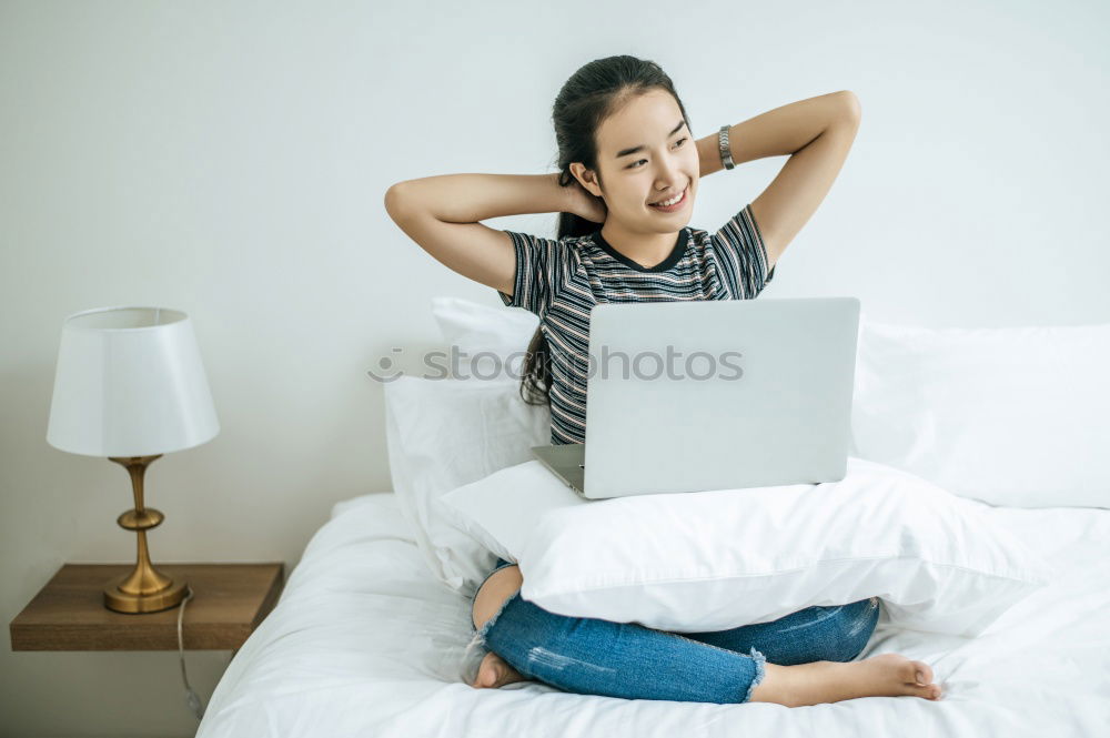 Similar – Young girl looking at mobile phone while sitting on bed