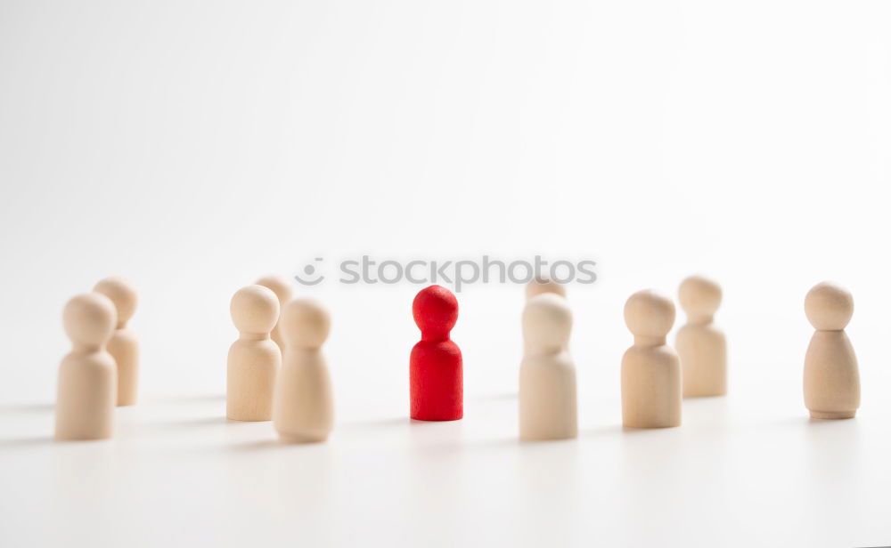 Similar – A single red figure stands apart from a row of black figures