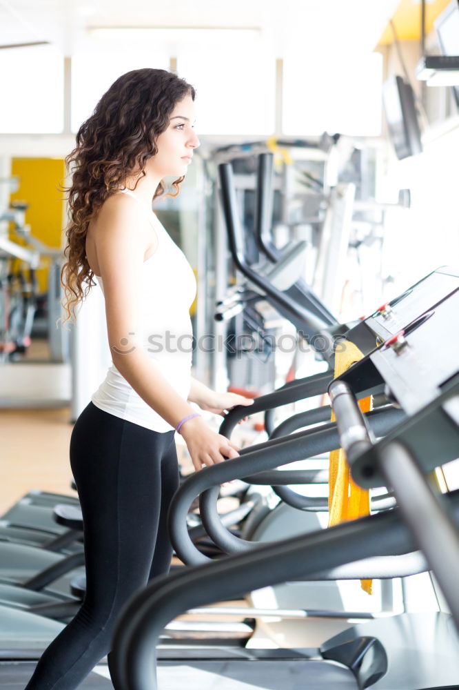 Similar – Woman drinking water while training on treadmill