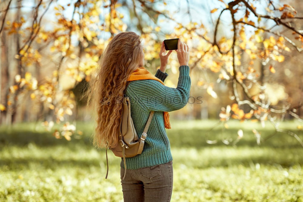 Similar – Smiling young woman using a camera to take photo at the park.