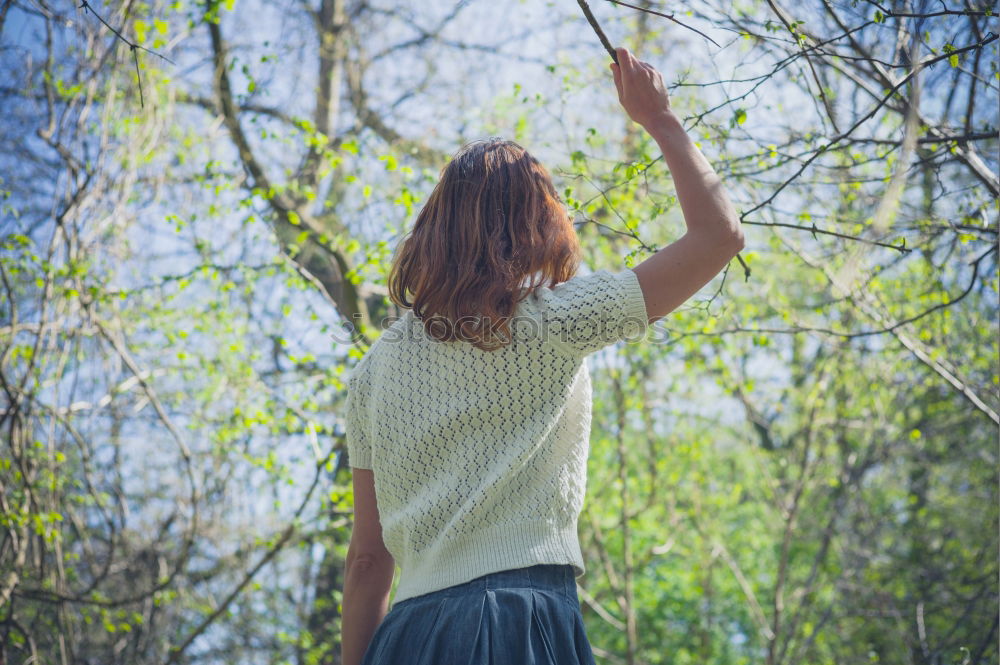 Similar – Winter ideas. Beautiful young girl stretching her finger upwards while snowing on a green meadow.