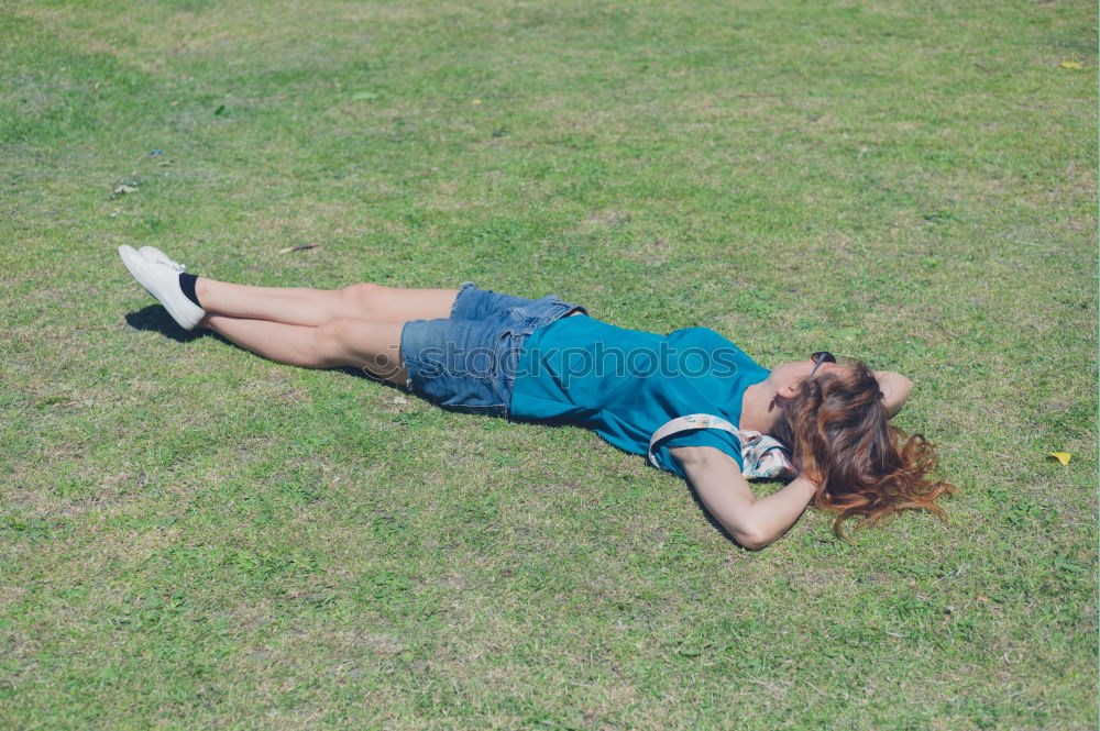 Similar – young cheerful woman lying down on the grass