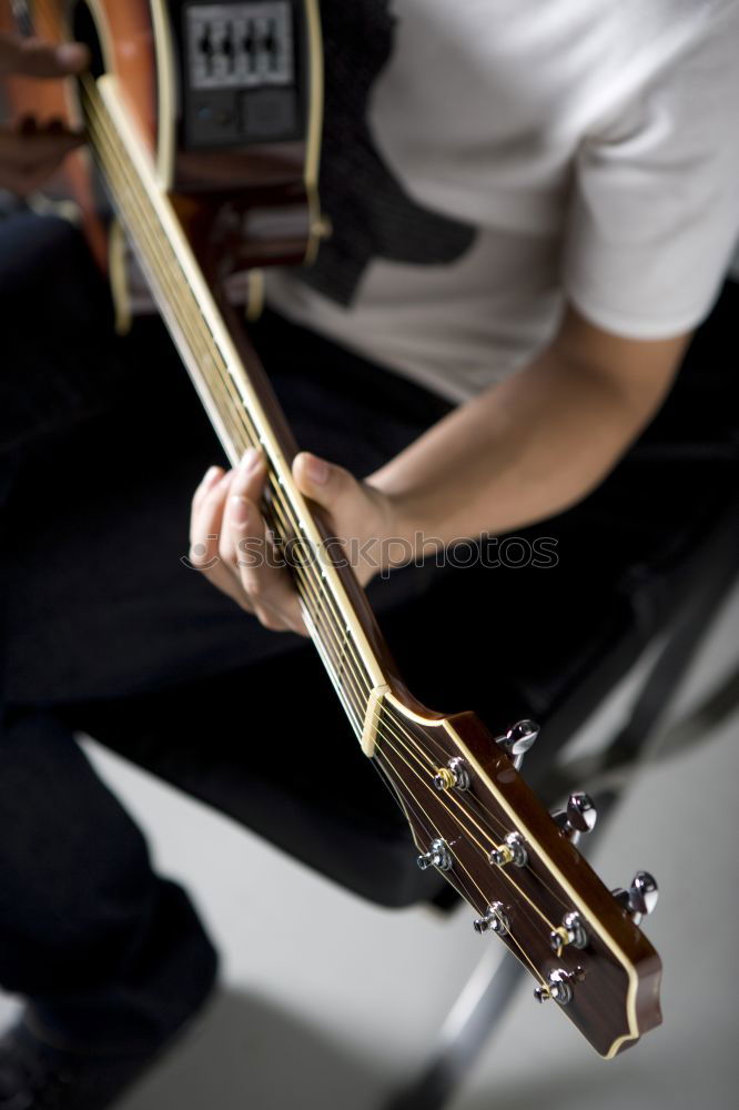 Similar – man playing spanish guitar and singing while recording it with a microphone