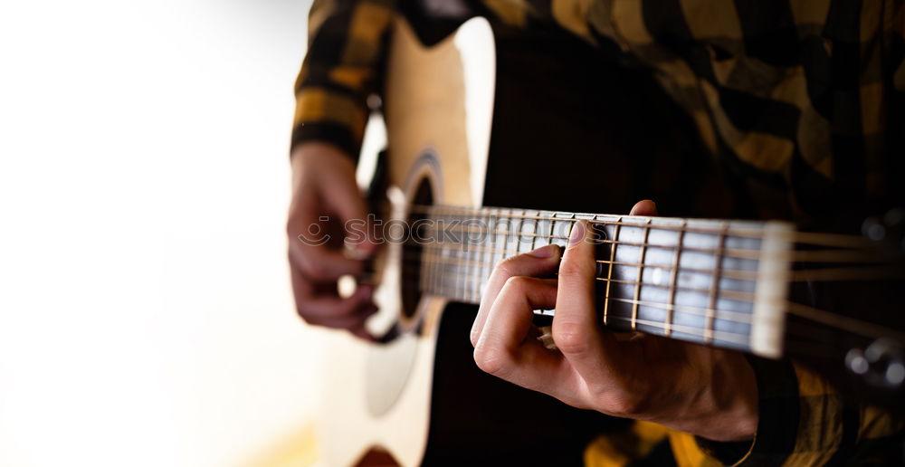 Similar – man playing spanish guitar and singing while recording it with a microphone