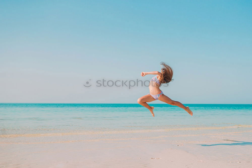 Happy teen girl jumping on the beach