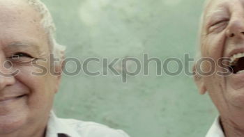 Similar – Image, Stock Photo Portrait of two laughing seniors, one with silver-grey curls and glasses, the other with cap in front of an old wall