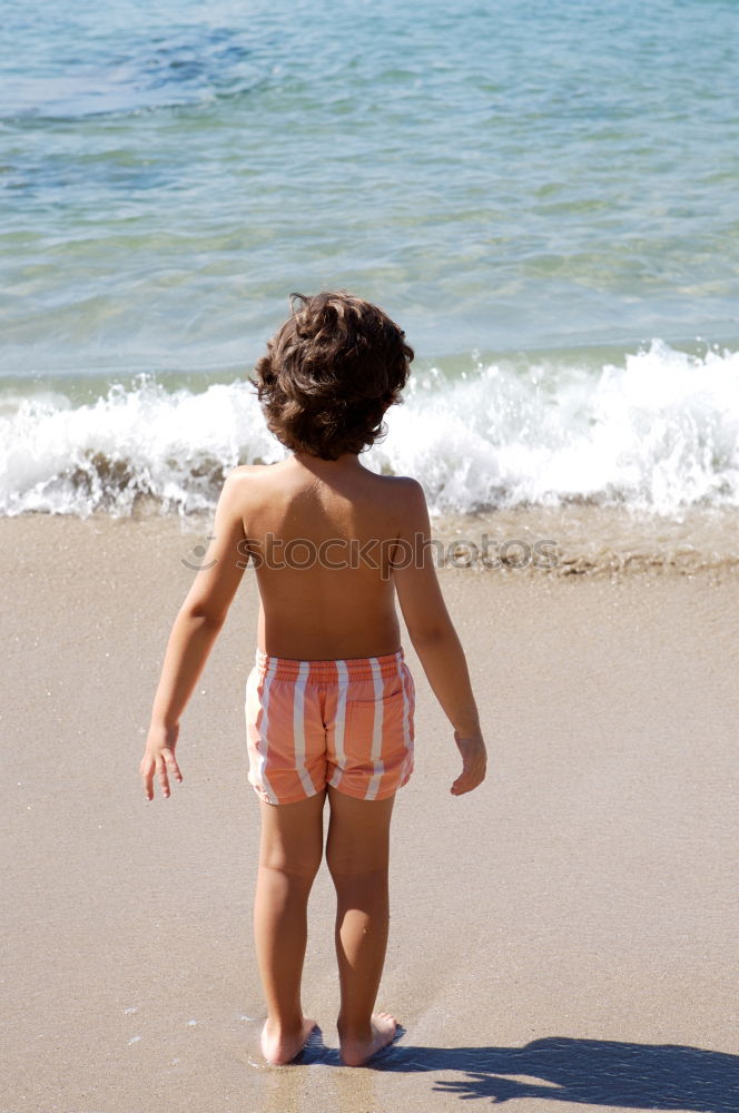 Similar – little girl stands on beach in a special swimsuit for children who can not swim. child in swimsuit, which he kept afloat