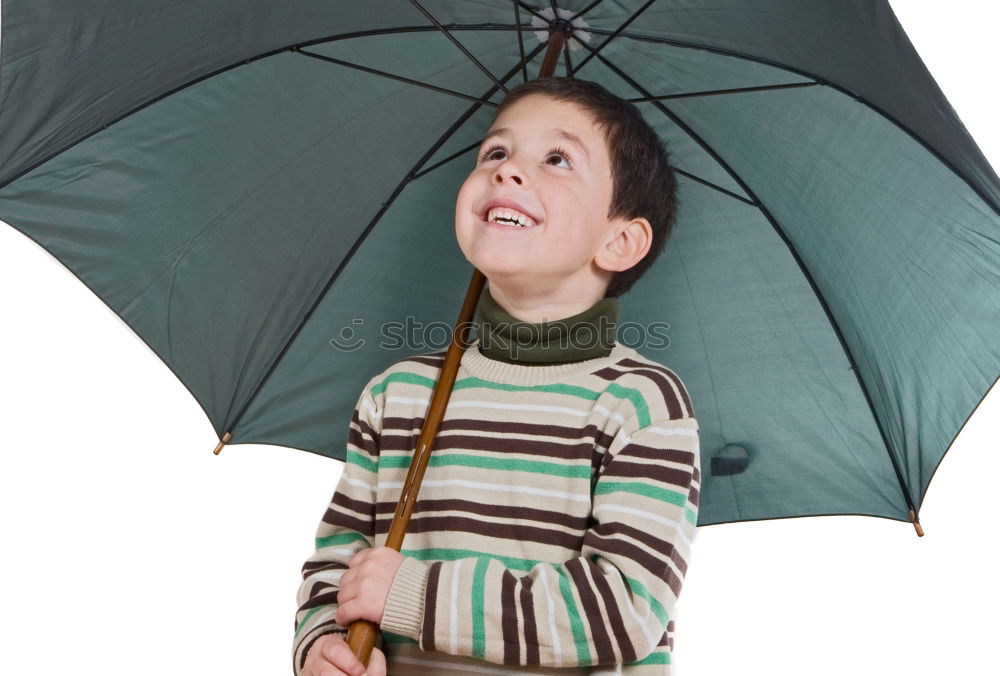 Little girl standing on rain wearing green raincoat