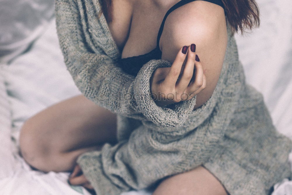 Similar – Young woman in undershirt sitting on a flowered couch and looking sideways into the camera