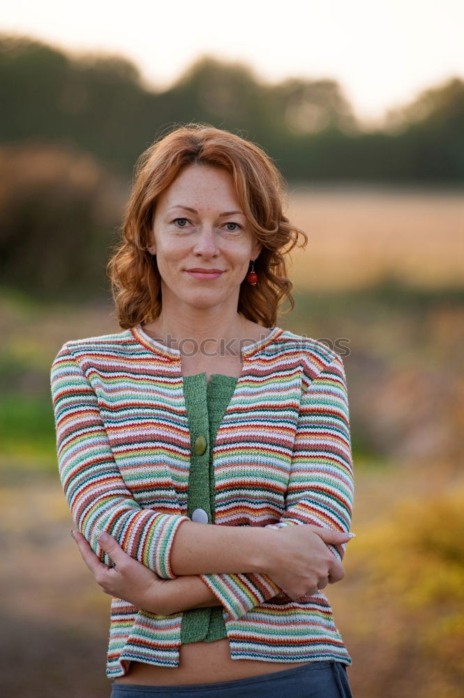 Similar – Portrait of an elderly woman with long red hair, looking mischievously to the side, with red jacket, black shirt and colourful necklace