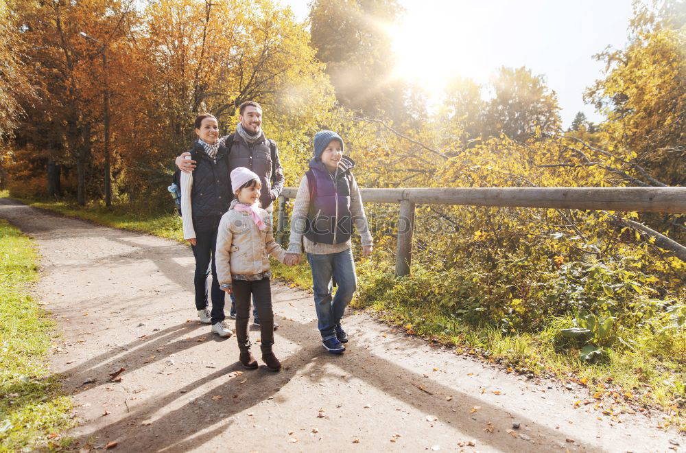 Happy family walking together holding hands in the forest