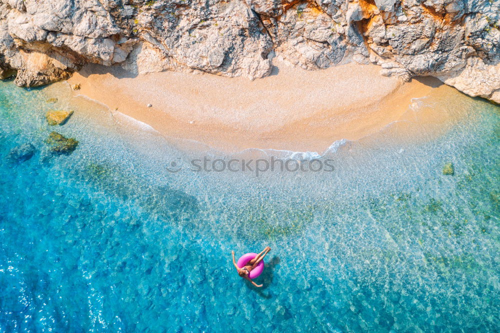 Boat anchors in rocky bay with turquoise blue sea from above