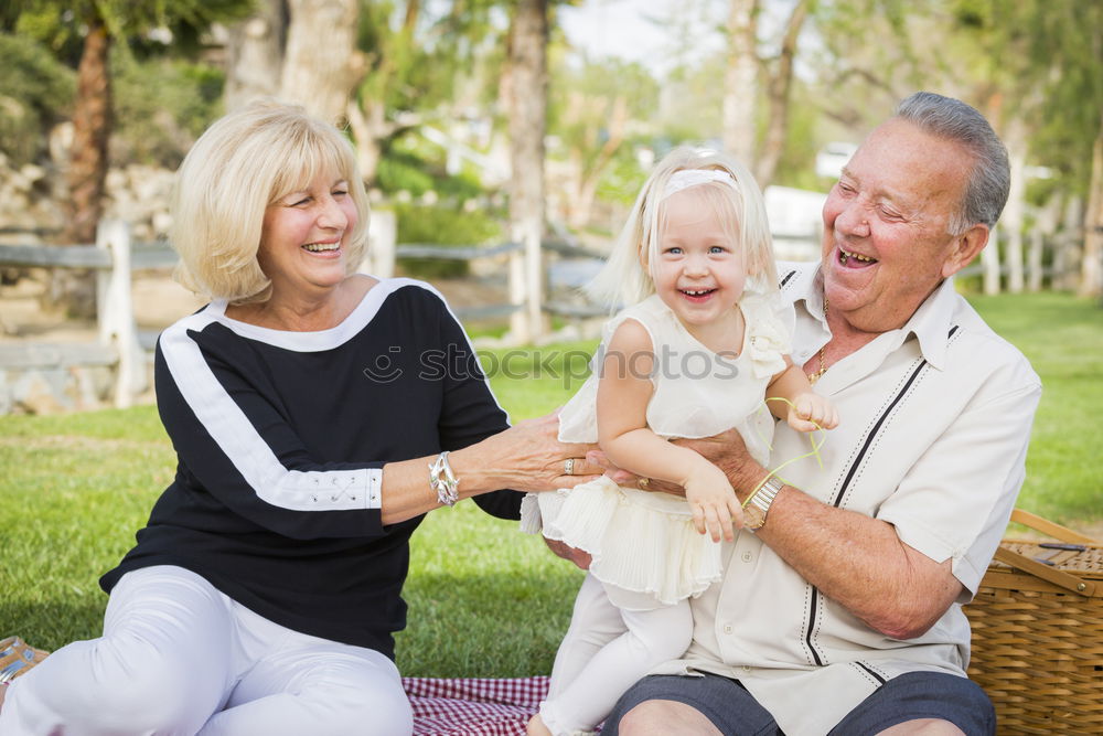 Similar – Image, Stock Photo Baby girl playing with hat of senior man over a nature background