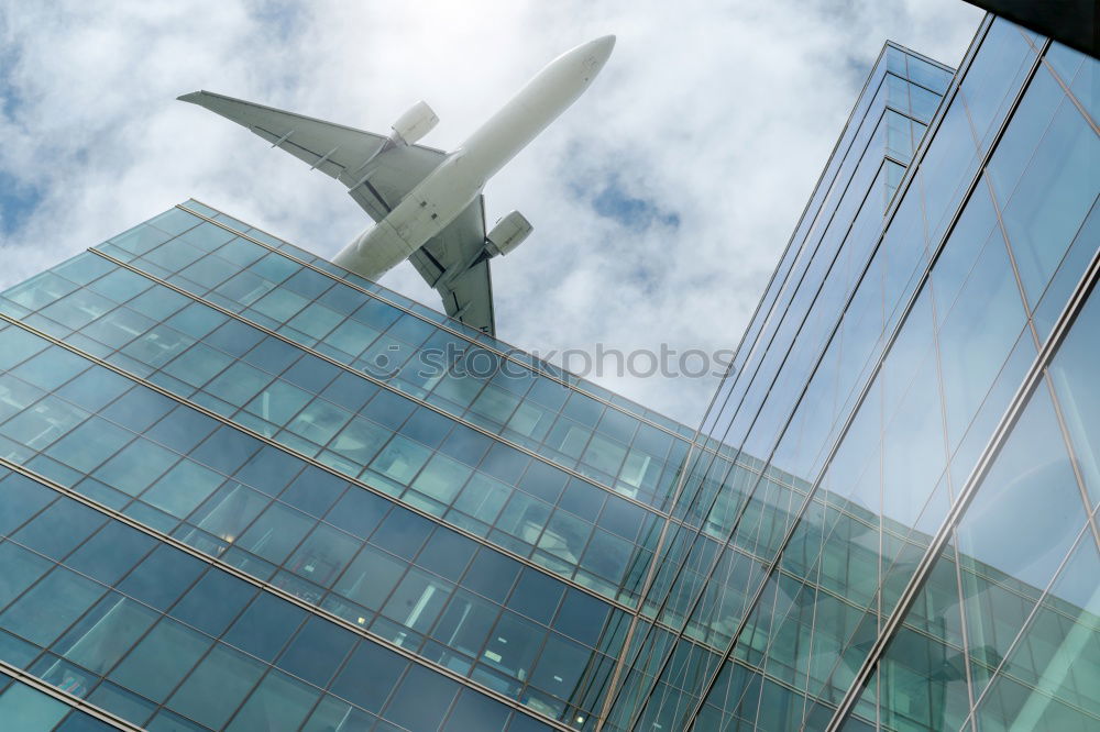 Similar – Plane flying over building