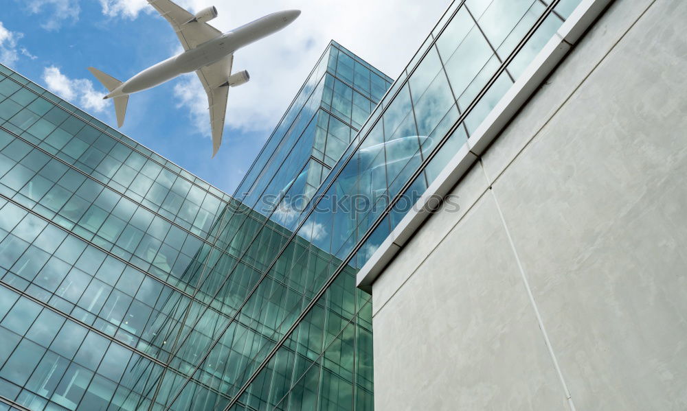 Similar – Plane flying over building