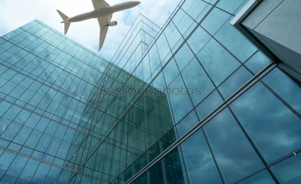 Similar – Plane flying over building