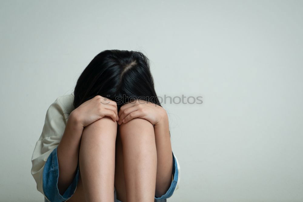 Similar – Image, Stock Photo young, slim, long-legged woman sits on the floor in front of a white wall and covers her face with one hand