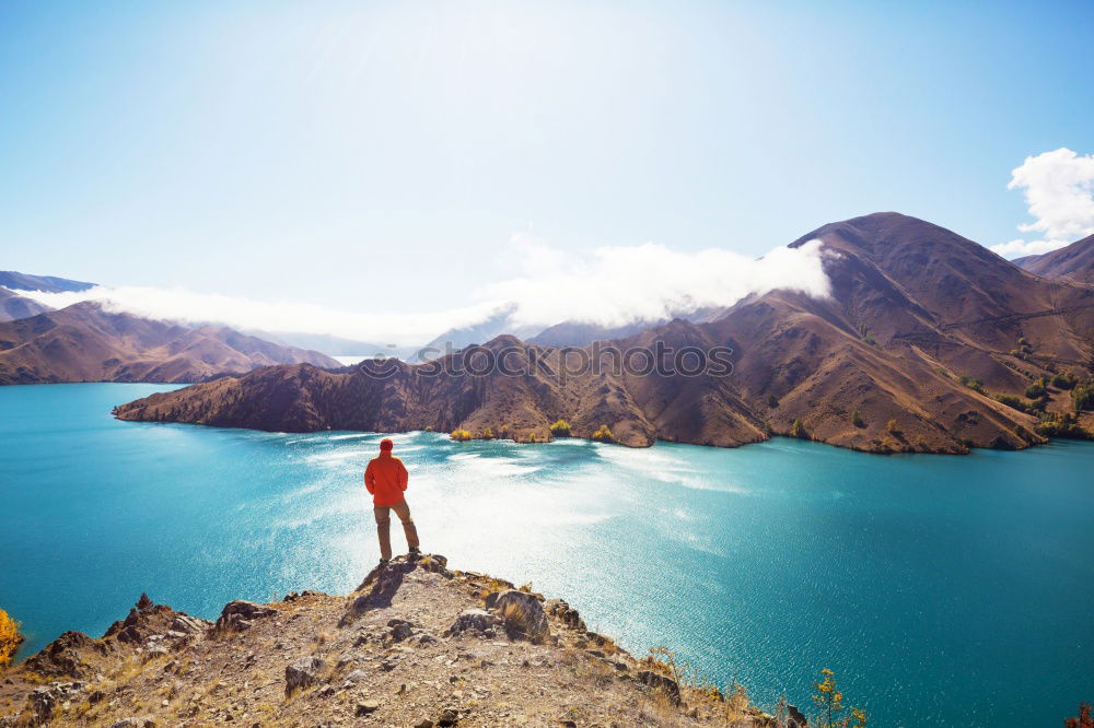 Similar – Woman sitting on stone at lake